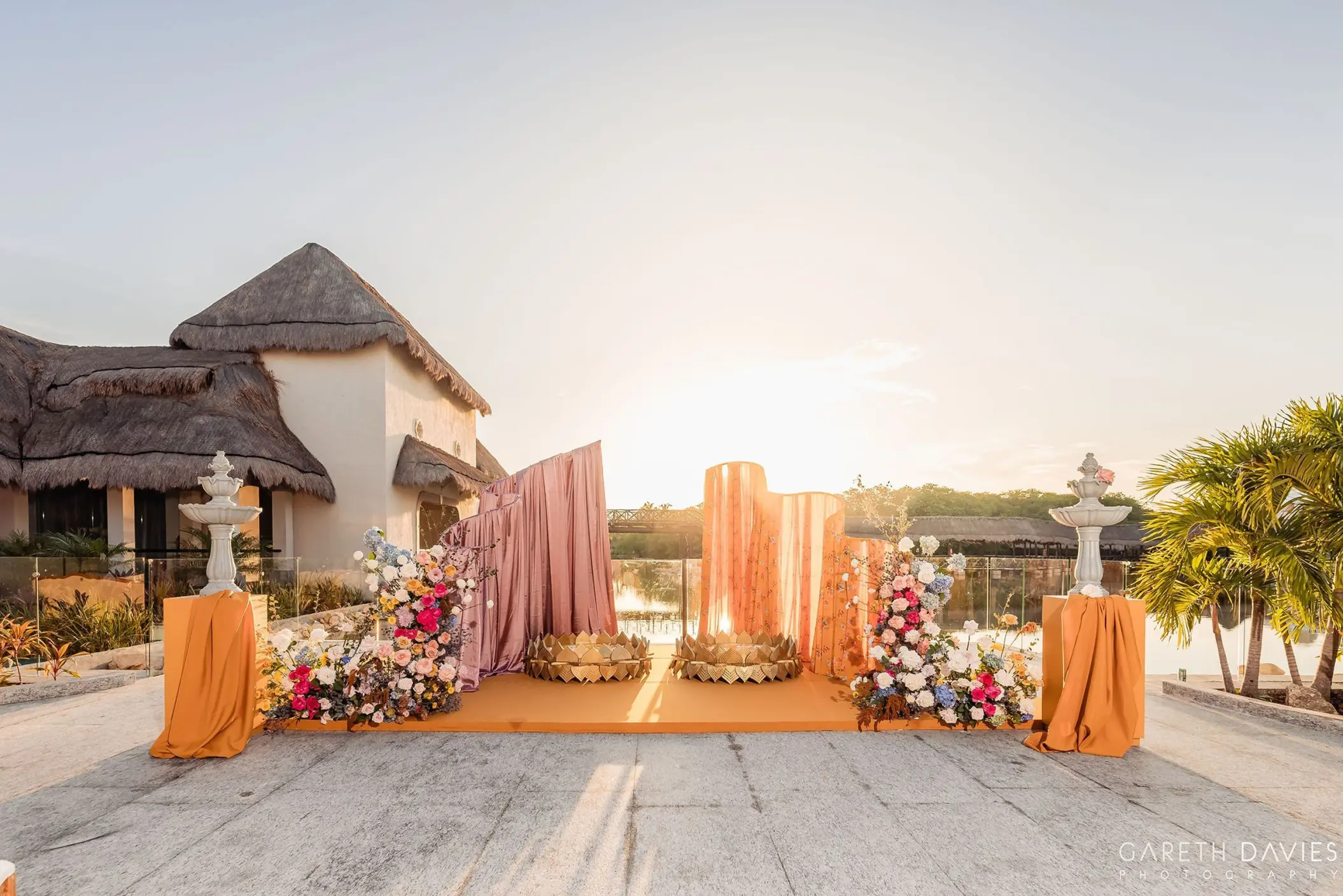 South Asian Haldi ceremony setup with orange and pink drapery at Grand Palladium, Riviera Maya