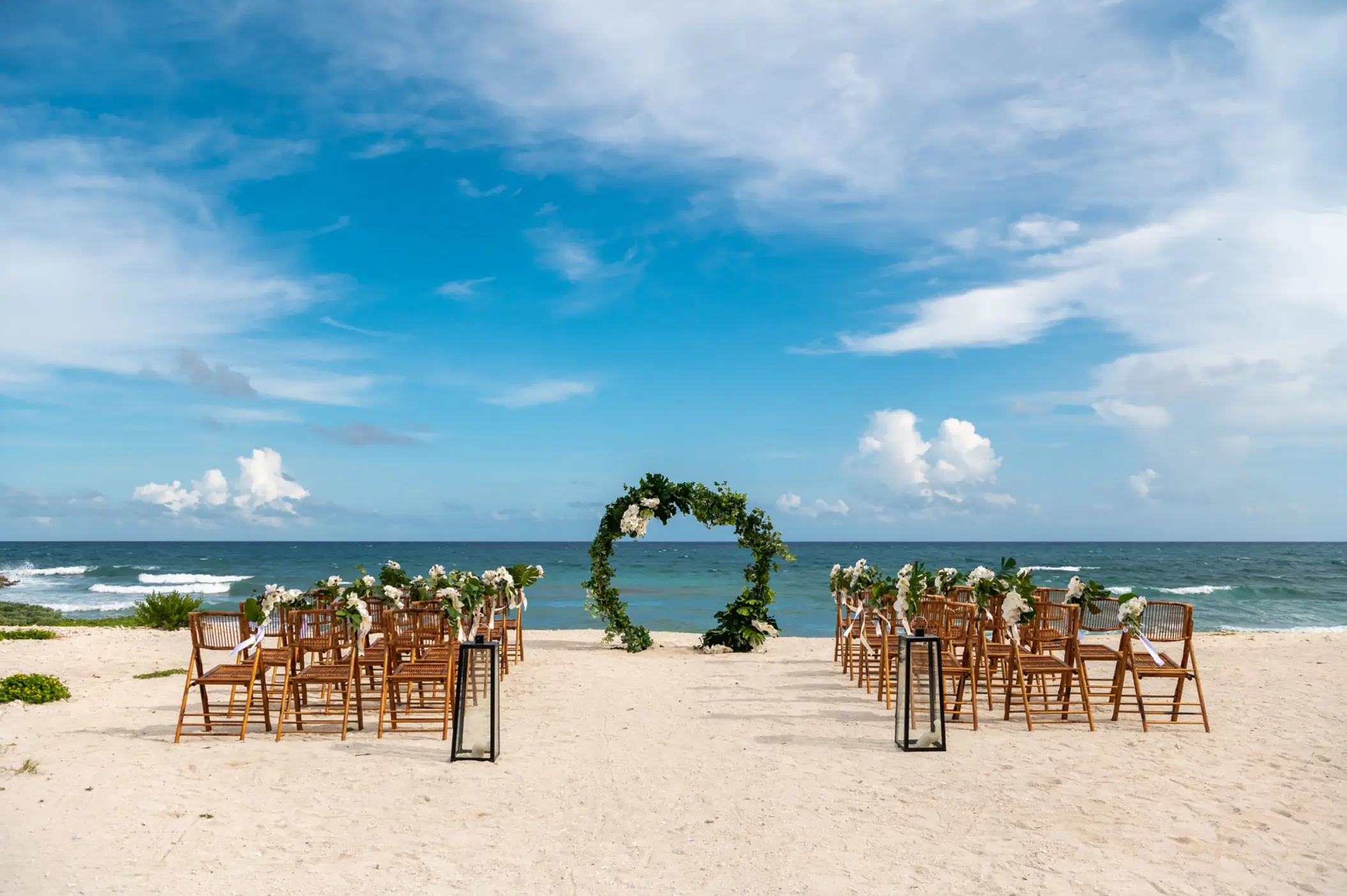 Beachfront wedding ceremony with a floral circle arch at Grand Sirenis Riviera Maya, Riviera Maya