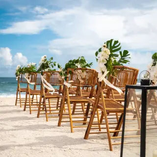 Beachfront wedding ceremony with bamboo chairs and white orchids at Grand Sirenis, Riviera Maya