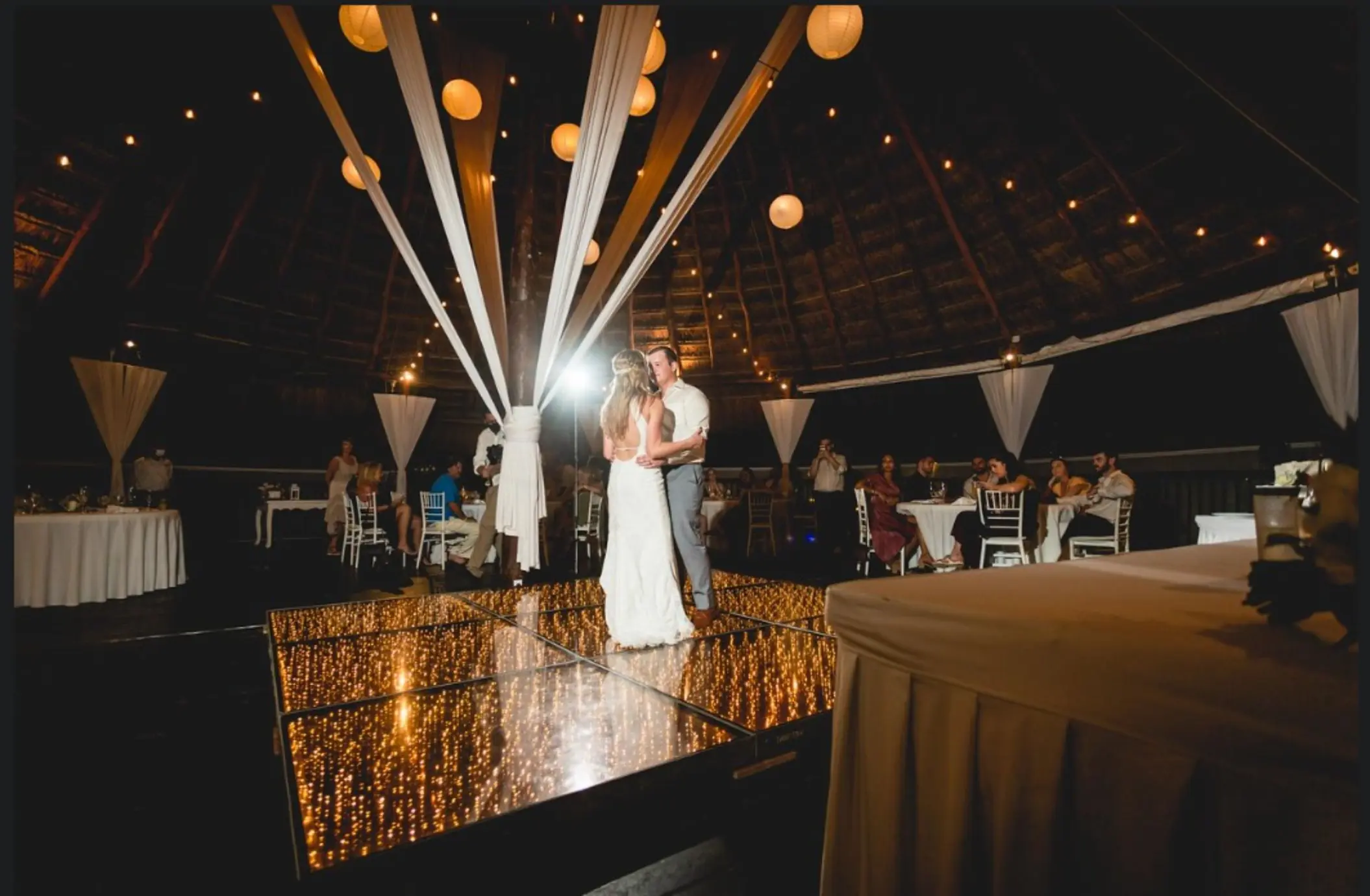bride and groom on the dance floor, with string lights, and paper lanterns at Grand Sirenis Riviera Maya
