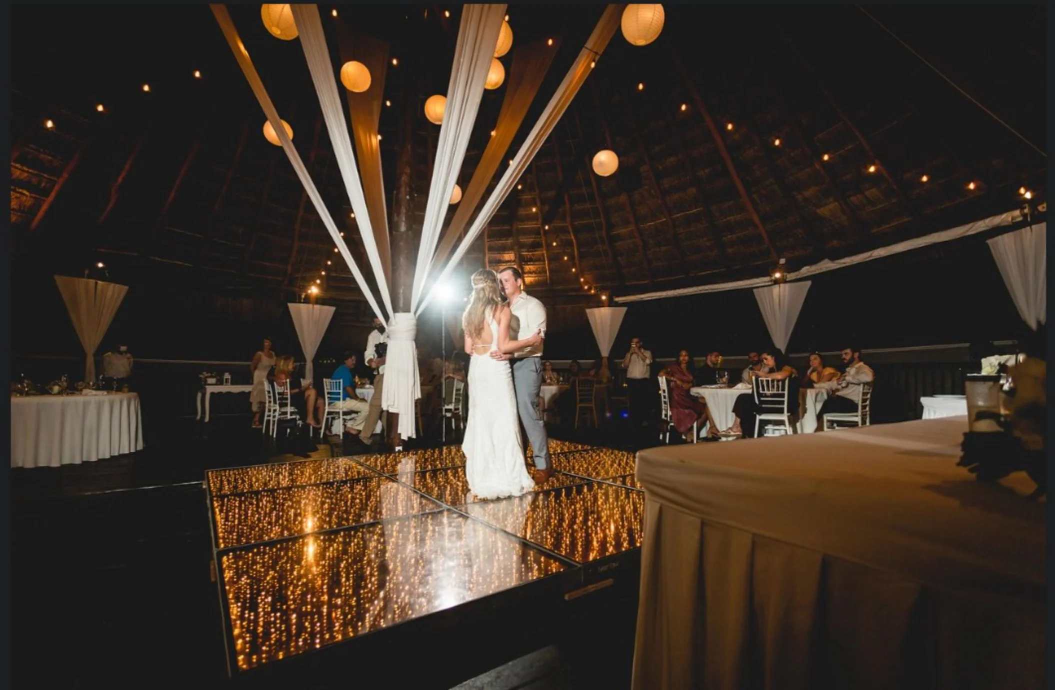 bride and groom on the dance floor, with string lights, and paper lanterns at Grand Sirenis Riviera Maya