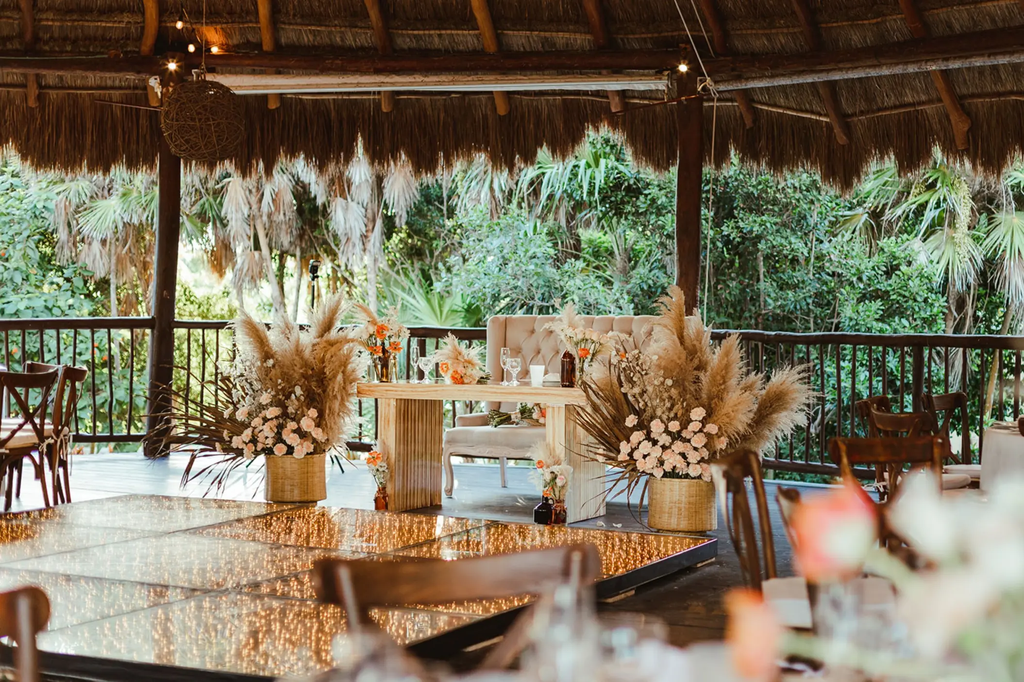 Palapa wedding reception with lighted dance floor and pampas grass at Grand Sirenis, Riviera Maya
