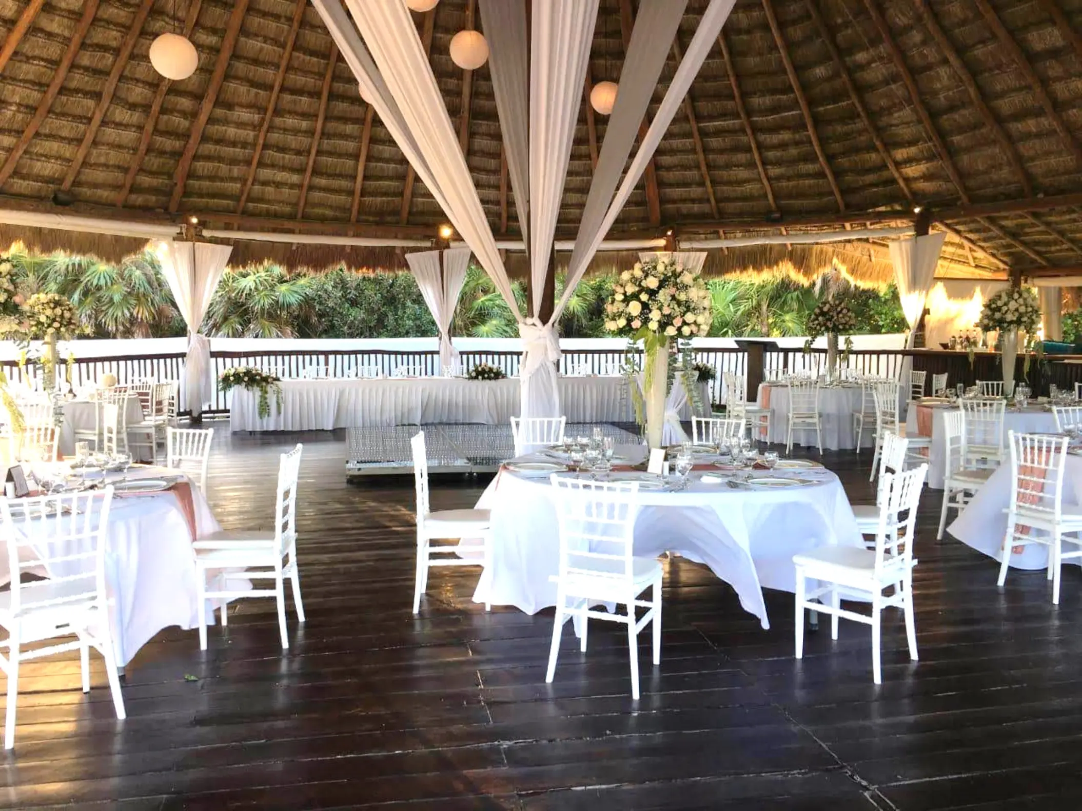 Palapa wedding reception with white tables and hanging drapes at Grand Sirenis, Riviera Maya