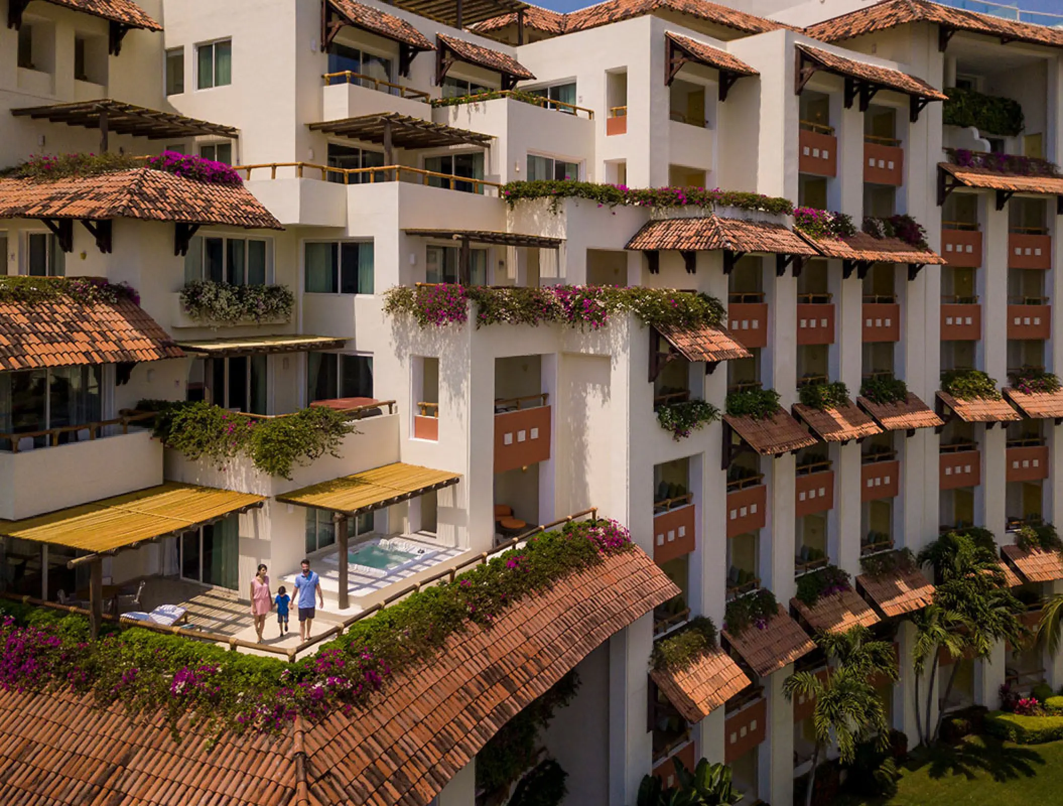 Terraced suite balconies with clay tile roofs and pink flowers at Grand Velas Riviera Nayarit, Puerto Vallarta