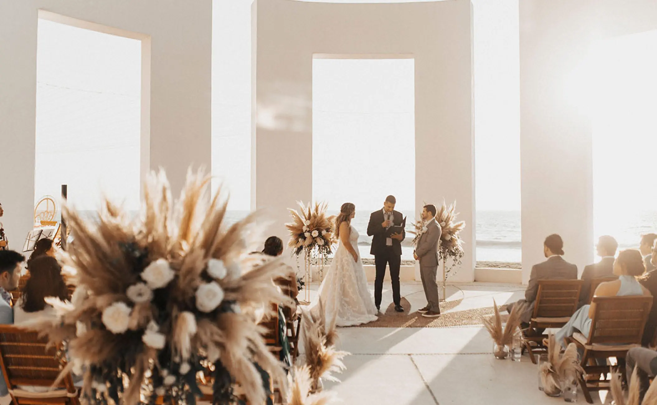 Outdoor wedding ceremony under a white stone terrace at Grand Velas Riviera Nayarit, Puerto Vallarta