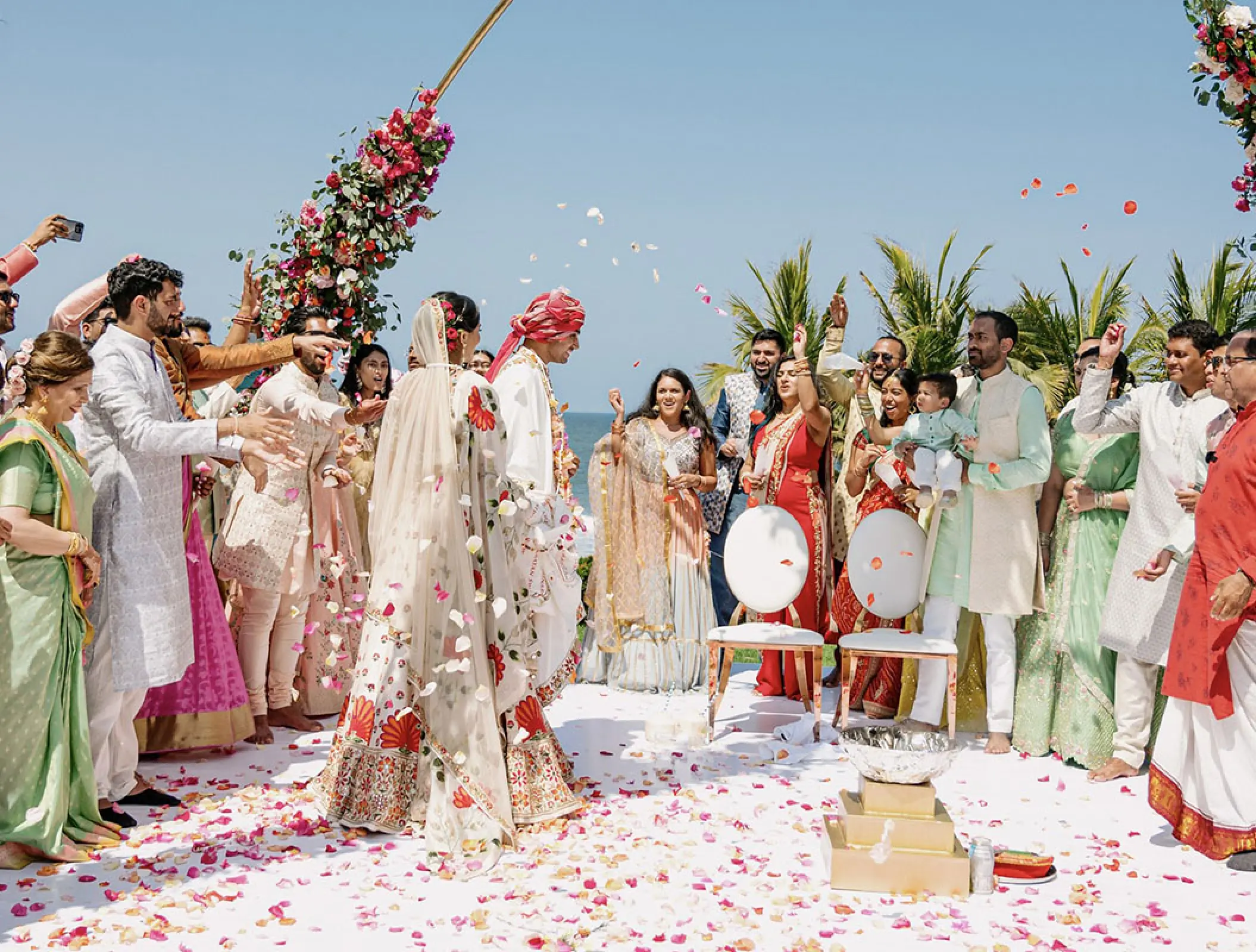 Guests tossing flower petals during a South Asian wedding ceremony at Grand Velas Riviera Nayarit, Puerto Vallarta