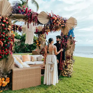 The bride and groom standing by a floral wedding lounge at Grand Velas Riviera Nayarit, Puerto Vallarta