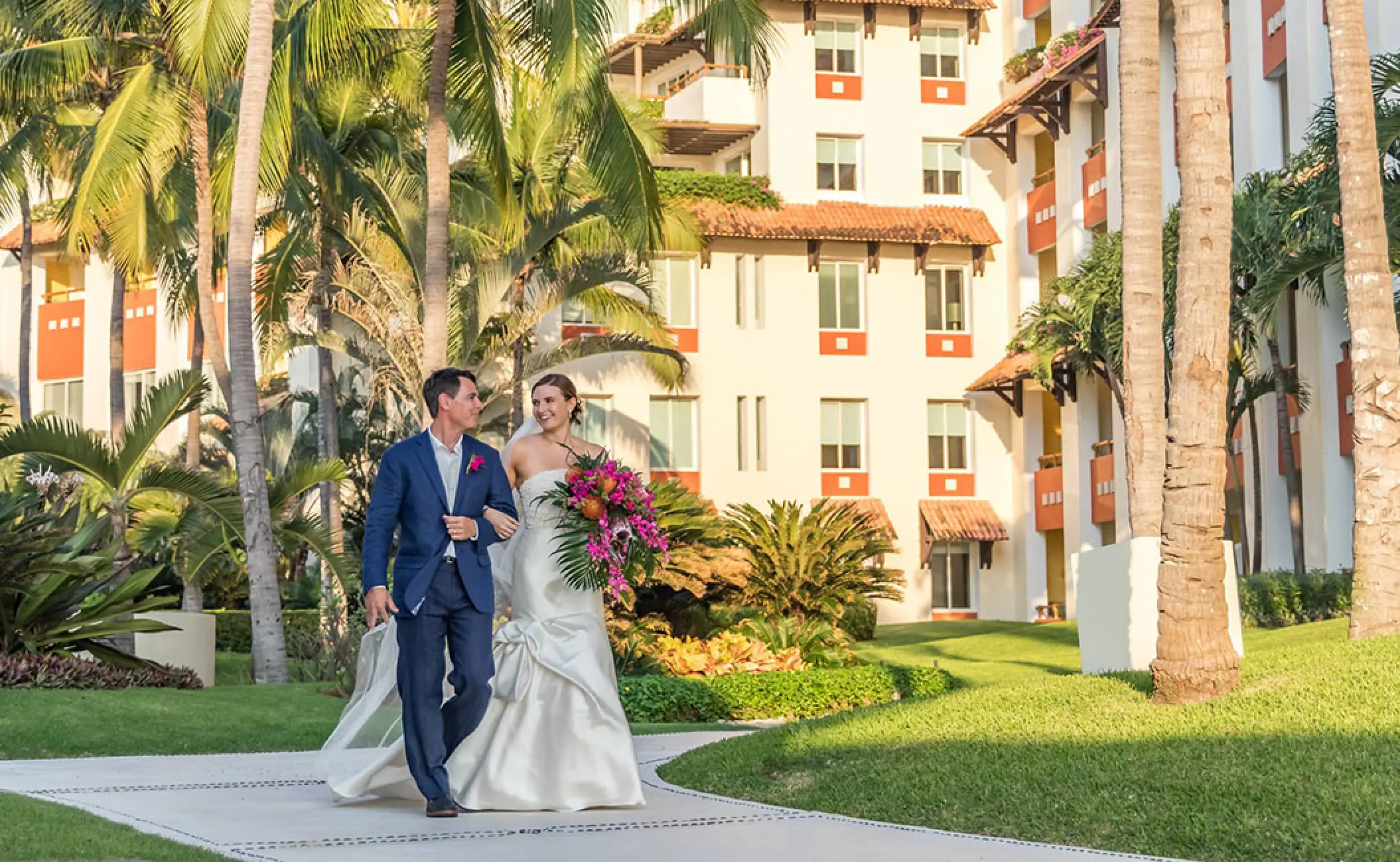 Newlyweds walking through the tropical grounds of Grand Velas Riviera Nayarit, Puerto Vallarta