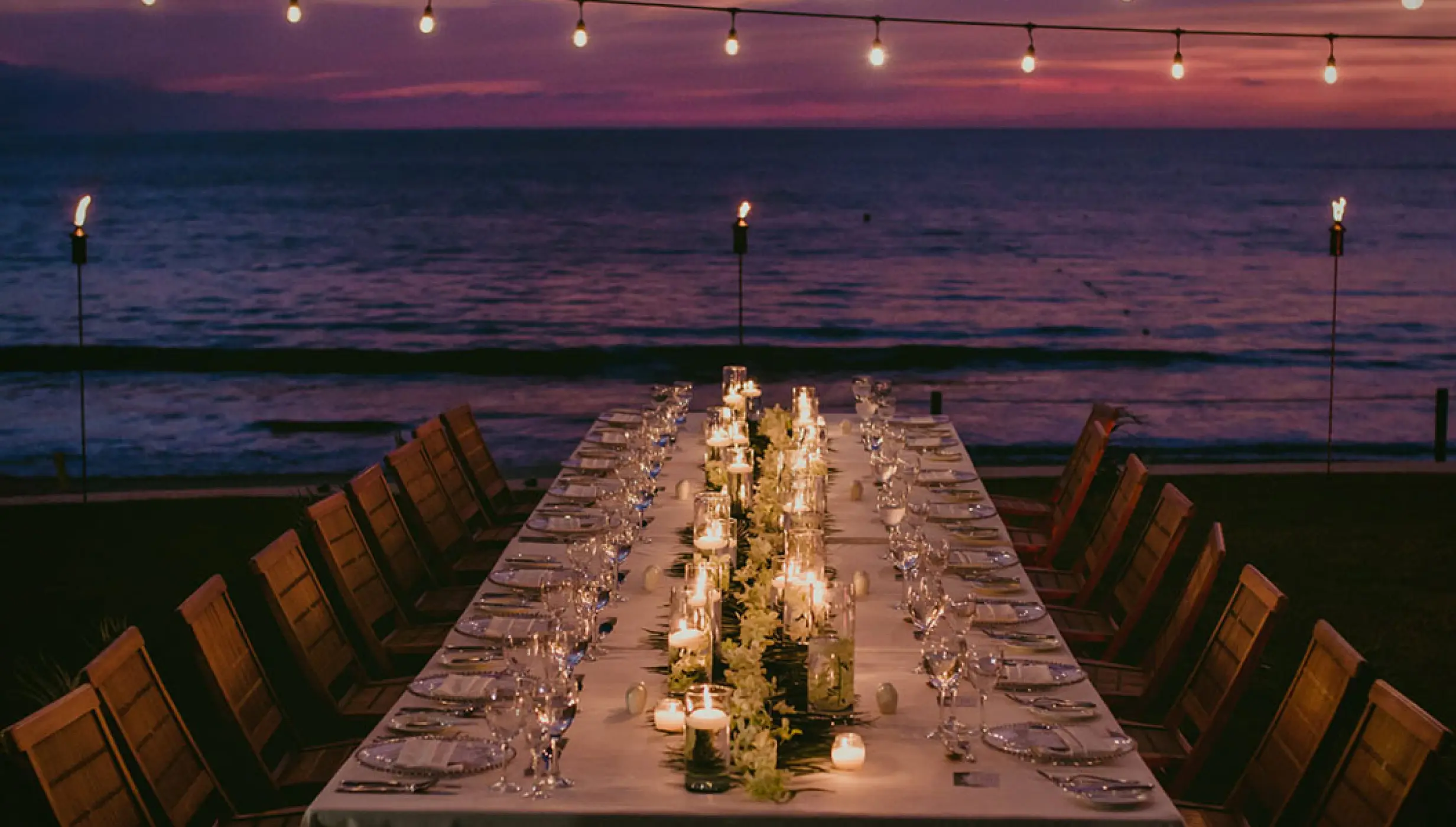 Long wedding reception table under string lights at sunset, Grand Velas Riviera Nayarit, Puerto Vallarta
