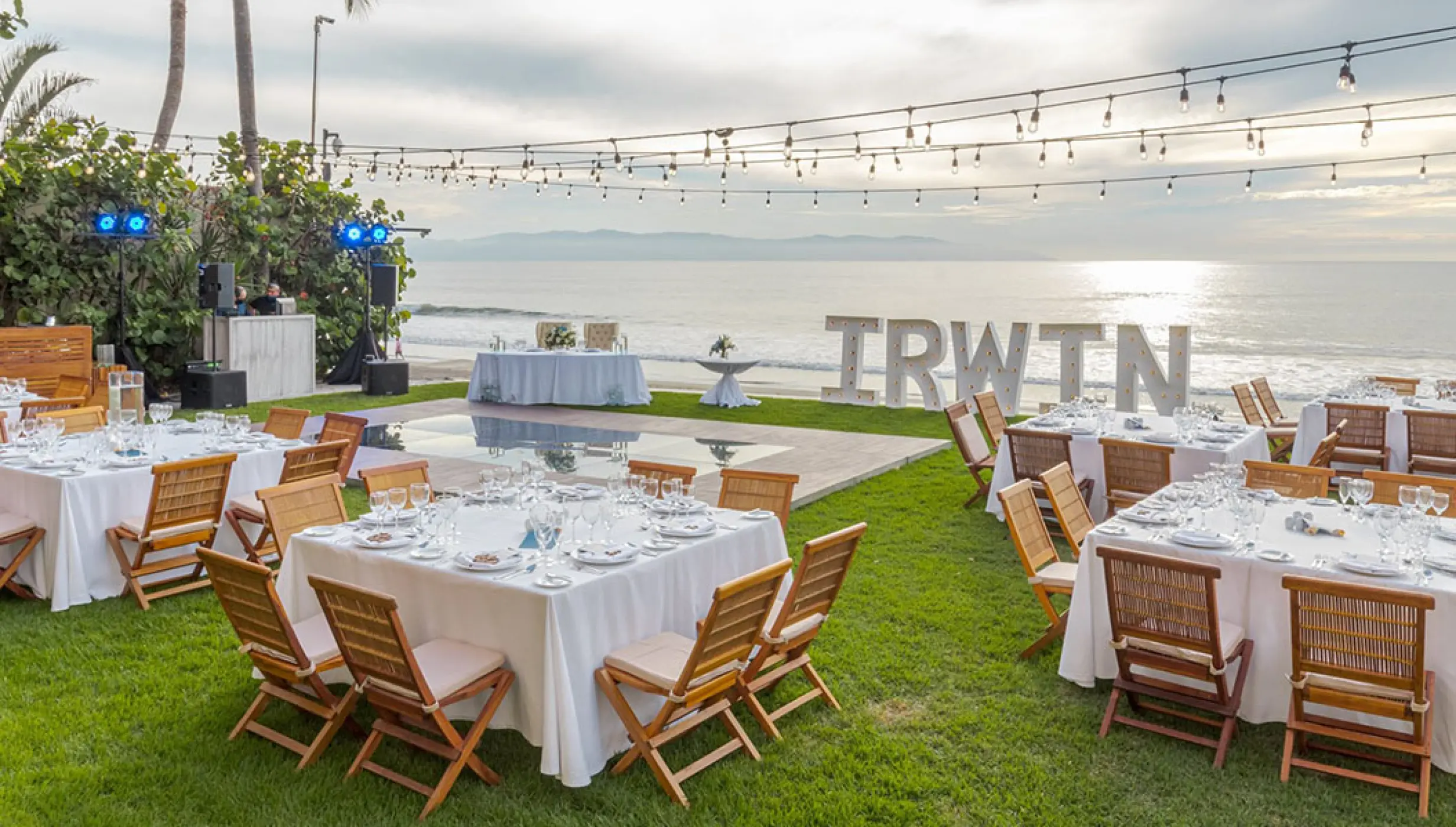 Outdoor wedding reception with white linens and string lights at Grand Velas Riviera Nayarit, Puerto Vallarta