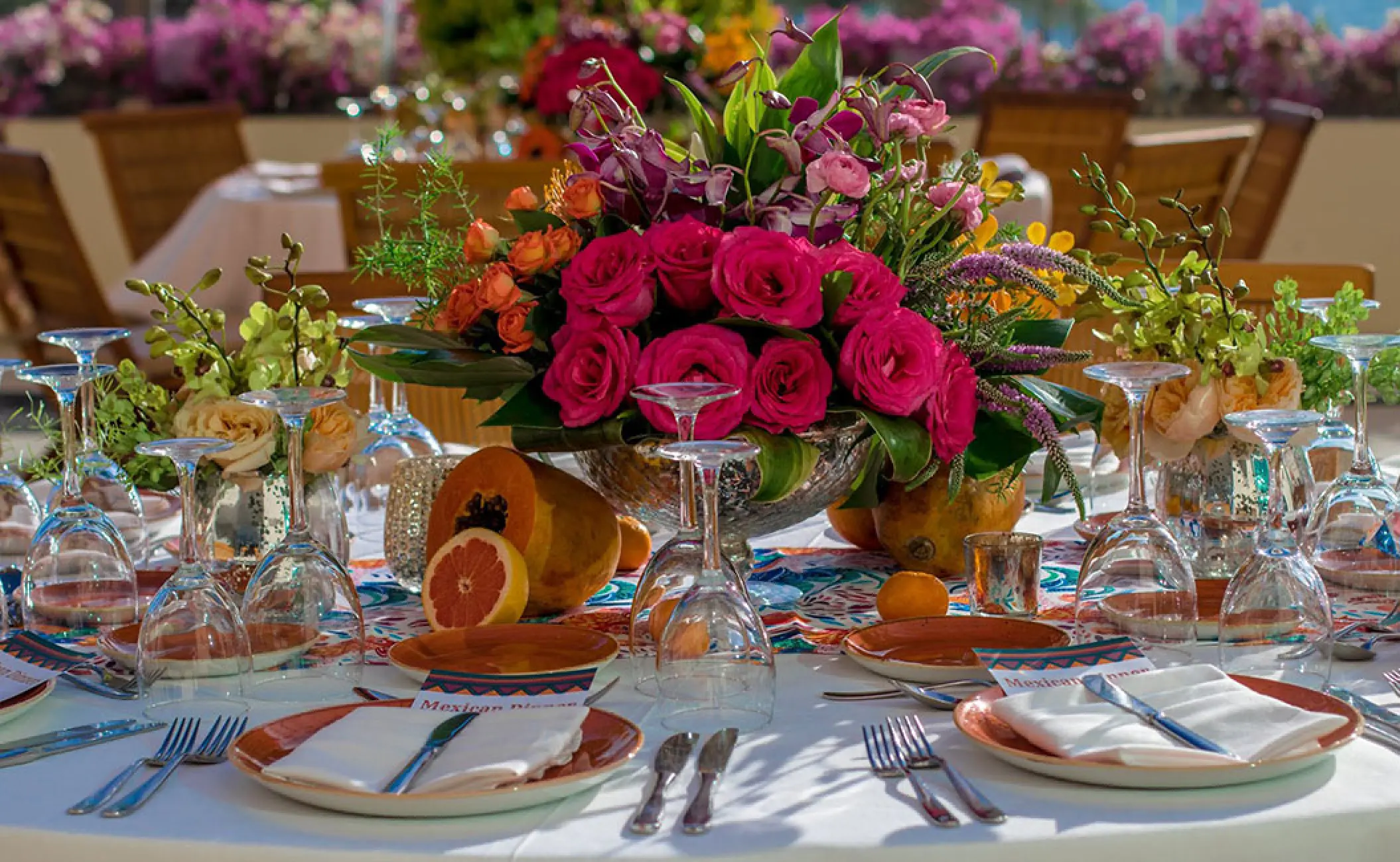 Colorful floral centerpiece and tropical fruit at a wedding reception at Grand Velas Riviera Nayarit, Puerto Vallarta