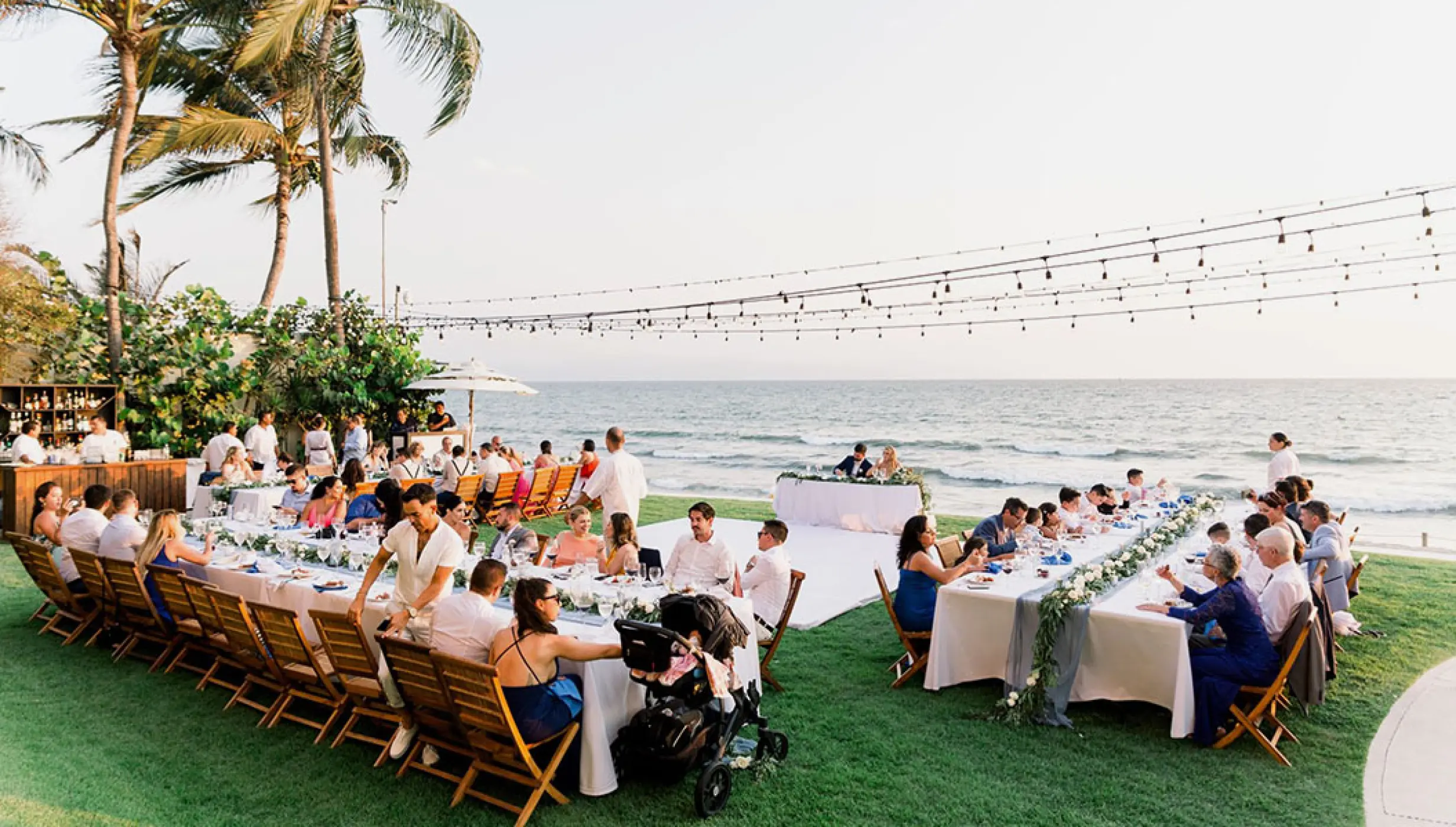 Outdoor wedding reception with long banquet tables on a lawn at Grand Velas Riviera Nayarit, Puerto Vallarta