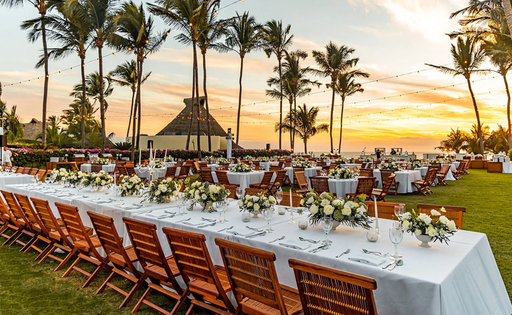 Outdoor wedding reception with long banquet tables and floral centerpieces at Grand Velas Riviera Nayarit, Puerto Vallarta