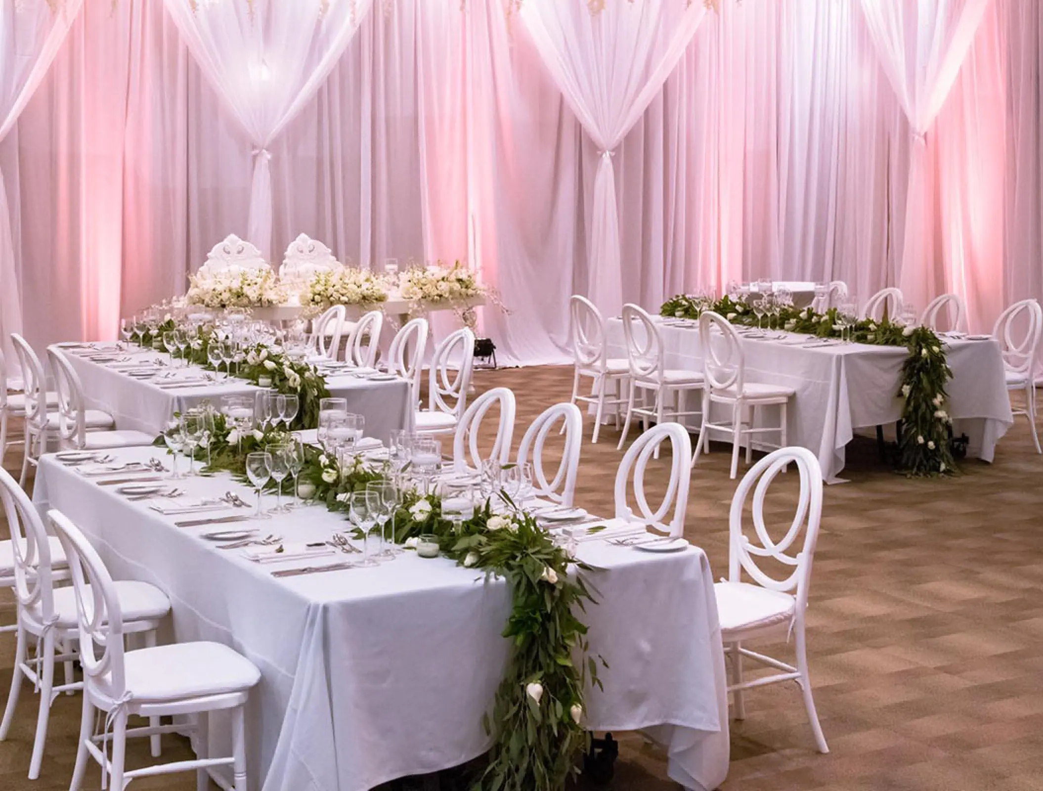 Ballroom wedding reception at Grand Velas Riviera Nayarit with white linens and long greenery centerpieces