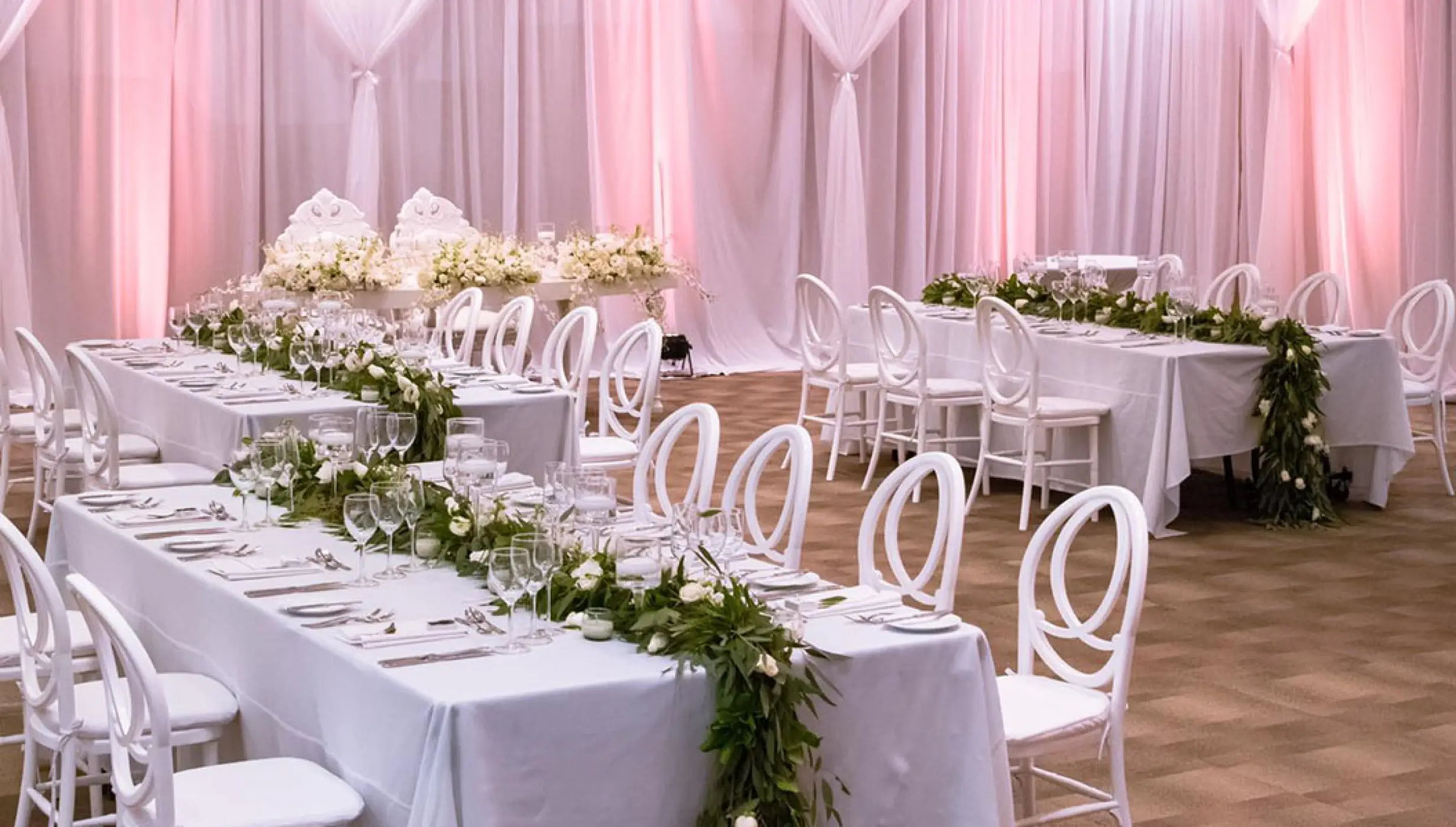 Ballroom wedding reception at Grand Velas Riviera Nayarit with white linens and long greenery centerpieces