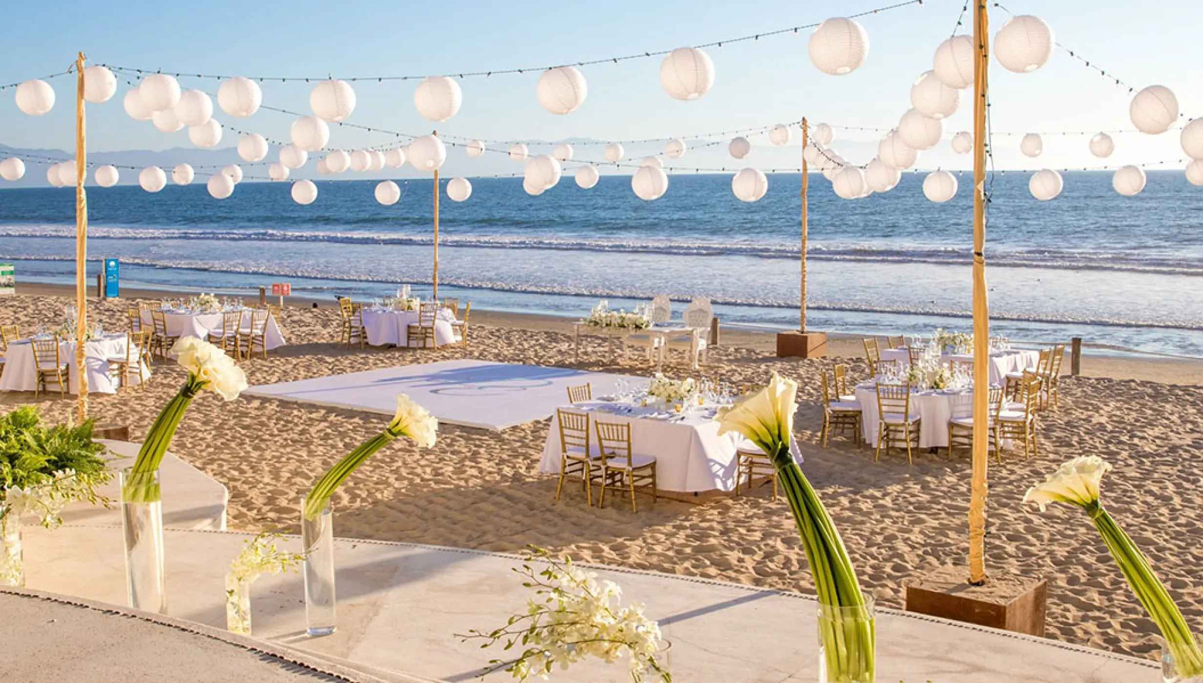 Beachfront wedding reception setup with white paper lanterns at Grand Velas Riviera Nayarit, Puerto Vallarta