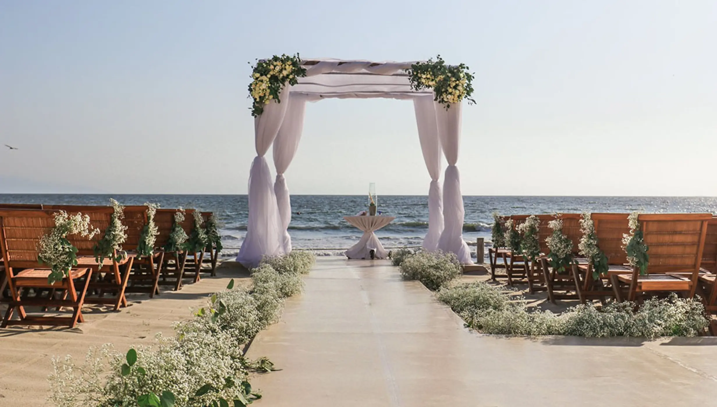 Beachfront wedding ceremony with a white draped huppah at Grand Velas Riviera Nayarit, Puerto Vallarta