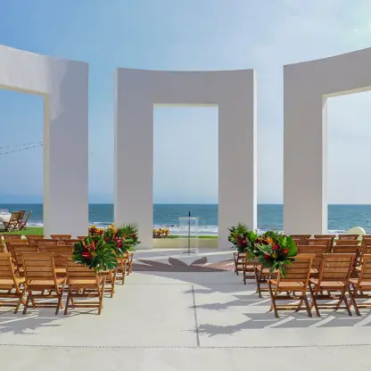 Terrace wedding ceremony with wooden chairs and white arches at Grand Velas Riviera Nayarit, Puerto Vallarta