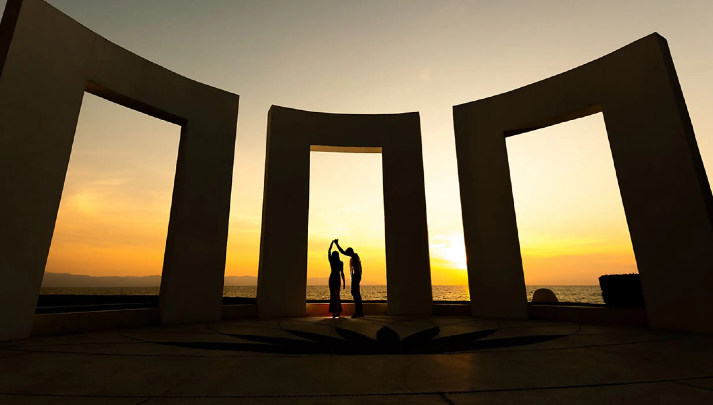 Silhouette of a couple dancing at sunset under a stone terrace at Grand Velas Riviera Nayarit, Puerto Vallarta
