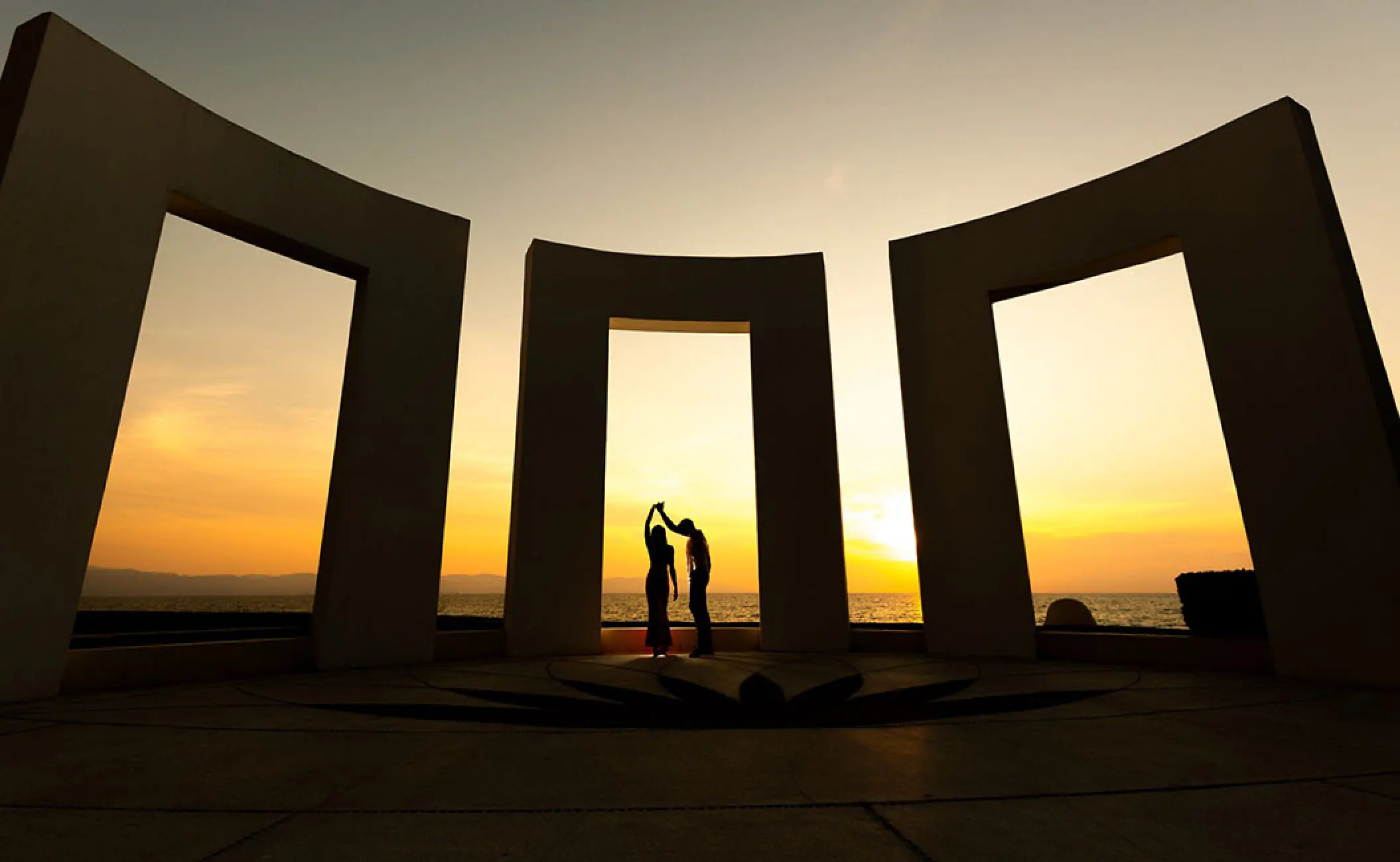 Silhouette of a couple dancing at sunset under a stone terrace at Grand Velas Riviera Nayarit, Puerto Vallarta