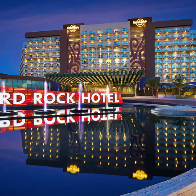 Illuminated Hard Rock Hotel Cancun sign and fountains at night, Cancun