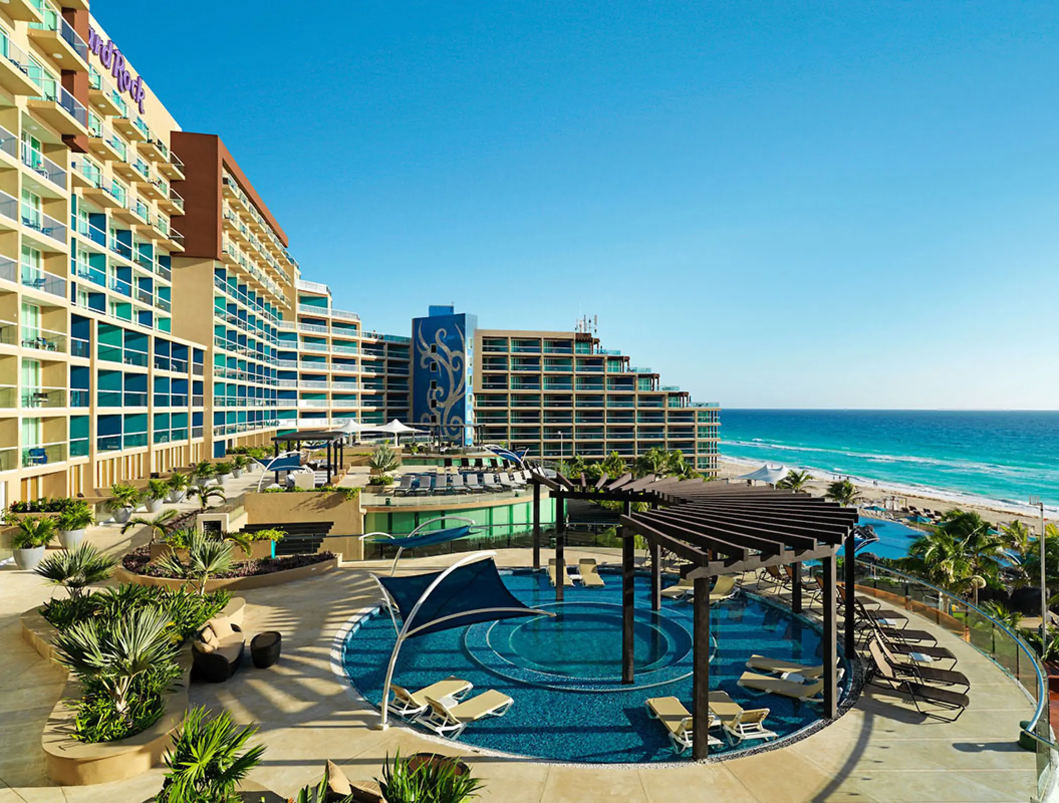 Hard Rock Cancun pool deck and modern hotel facade overlooking the turquoise Caribbean Sea, Cancun
