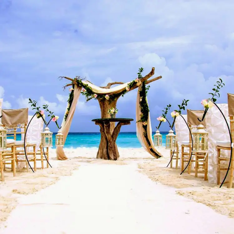 Beach wedding ceremony with driftwood arch and bamboo chairs at Hard Rock Cancun