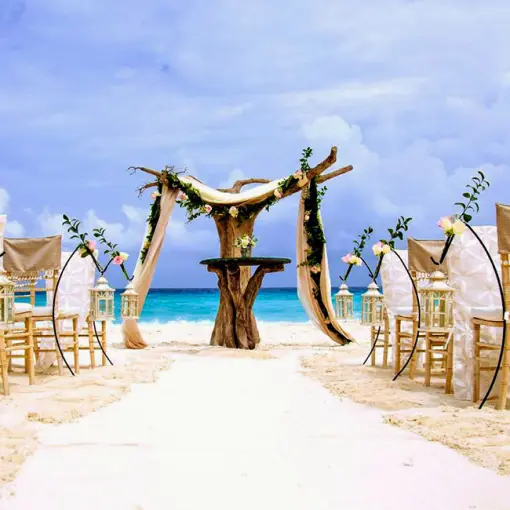 Beach wedding ceremony with driftwood arch and bamboo chairs at Hard Rock Cancun