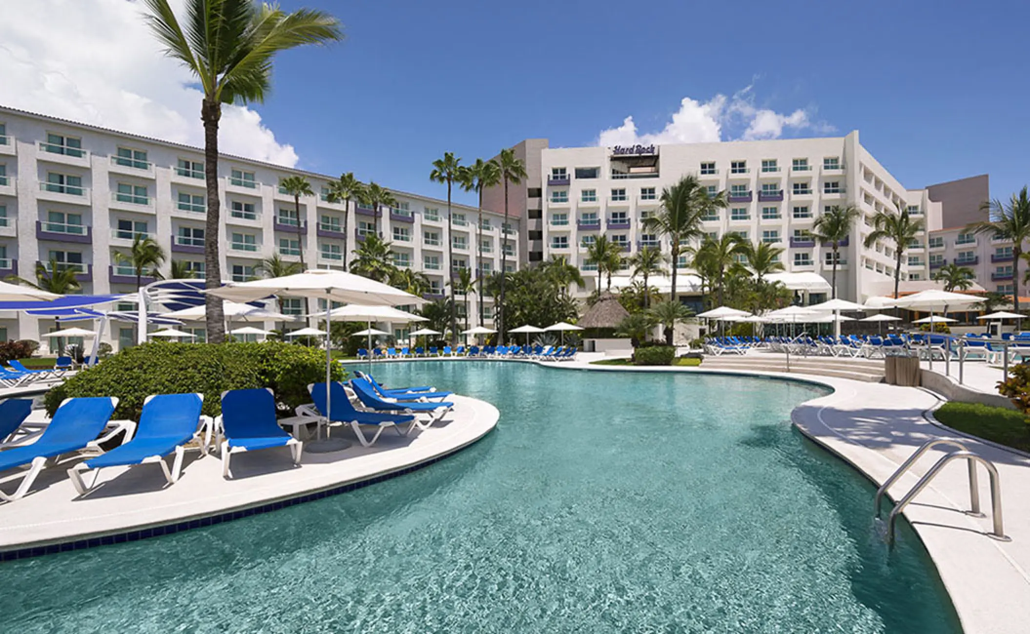 Hard Rock Vallarta pool area with blue lounge chairs and palm trees, Puerto Vallarta