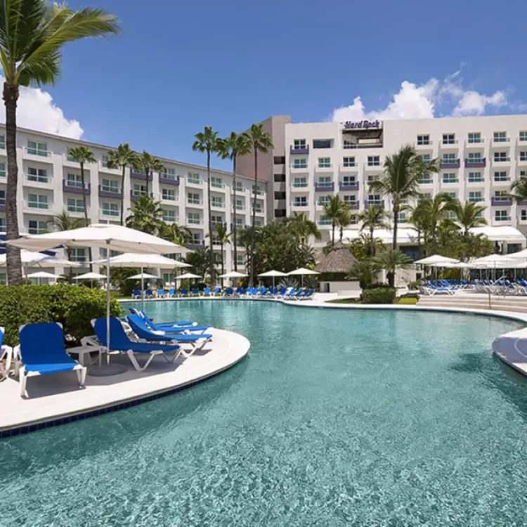 Hard Rock Vallarta pool area with blue lounge chairs and palm trees, Puerto Vallarta