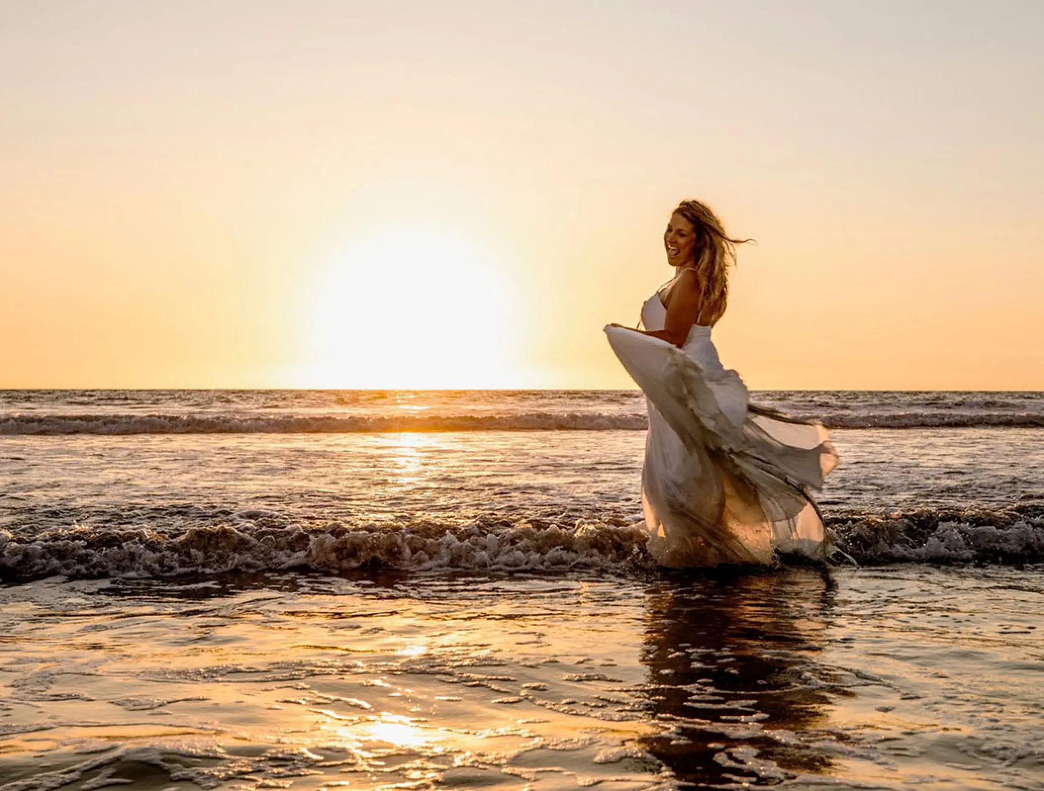 Bride walking through the surf at sunset, Hard Rock Hotel Vallarta