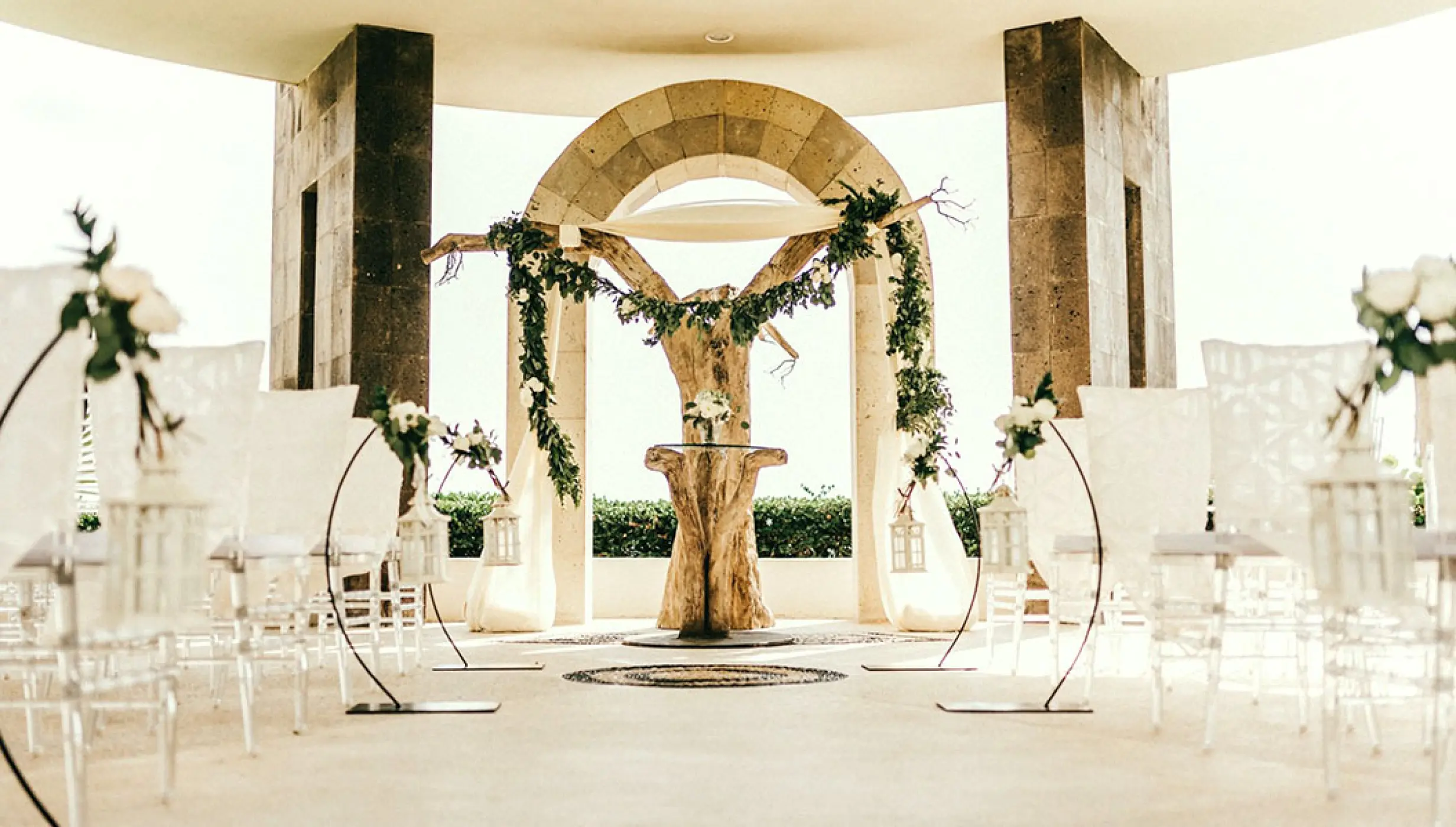 Stone gazebo wedding ceremony setup with white chairs and floral arch at Hard Rock Hotel Vallarta, Puerto Vallarta
