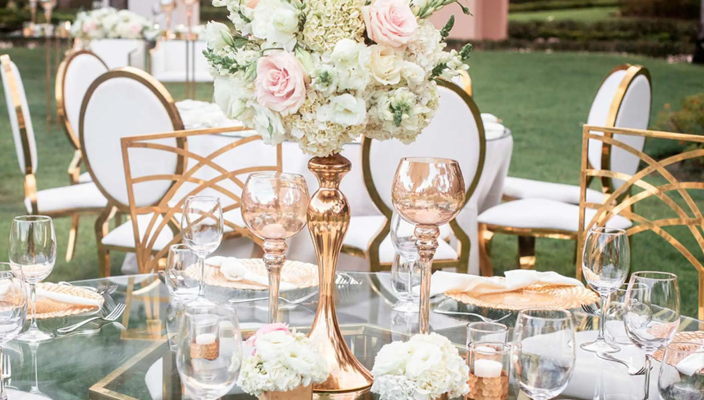 Outdoor wedding reception table with gold centerpieces and white roses at Hard Rock Vallarta, Puerto Vallarta