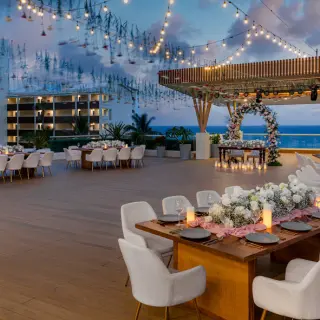 Rooftop wedding reception at Hilton Cancun Mar Caribe with string lights and ocean views, Cancun