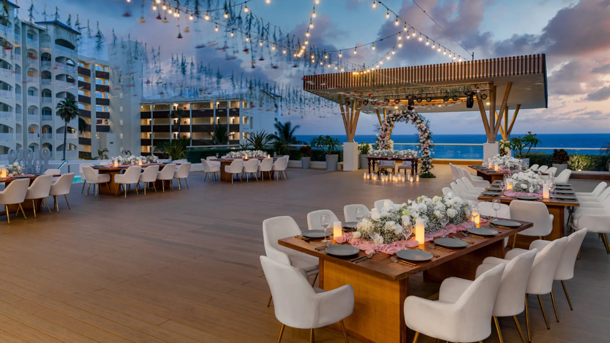 Rooftop wedding reception at Hilton Cancun Mar Caribe with string lights and ocean views, Cancun