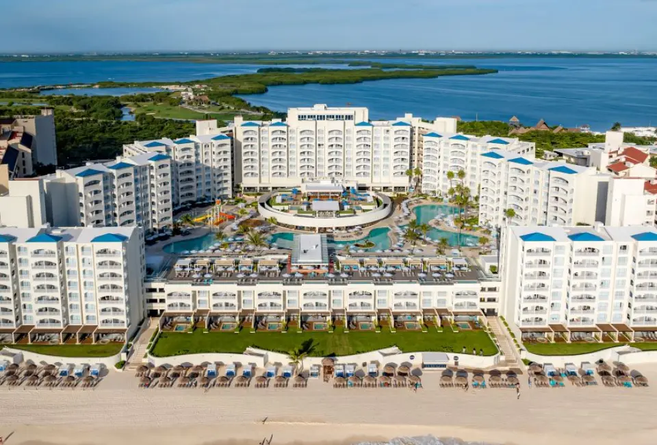 Aerial view of Hilton Cancun Mar Caribe buildings and pools overlooking the turquoise ocean, Cancun
