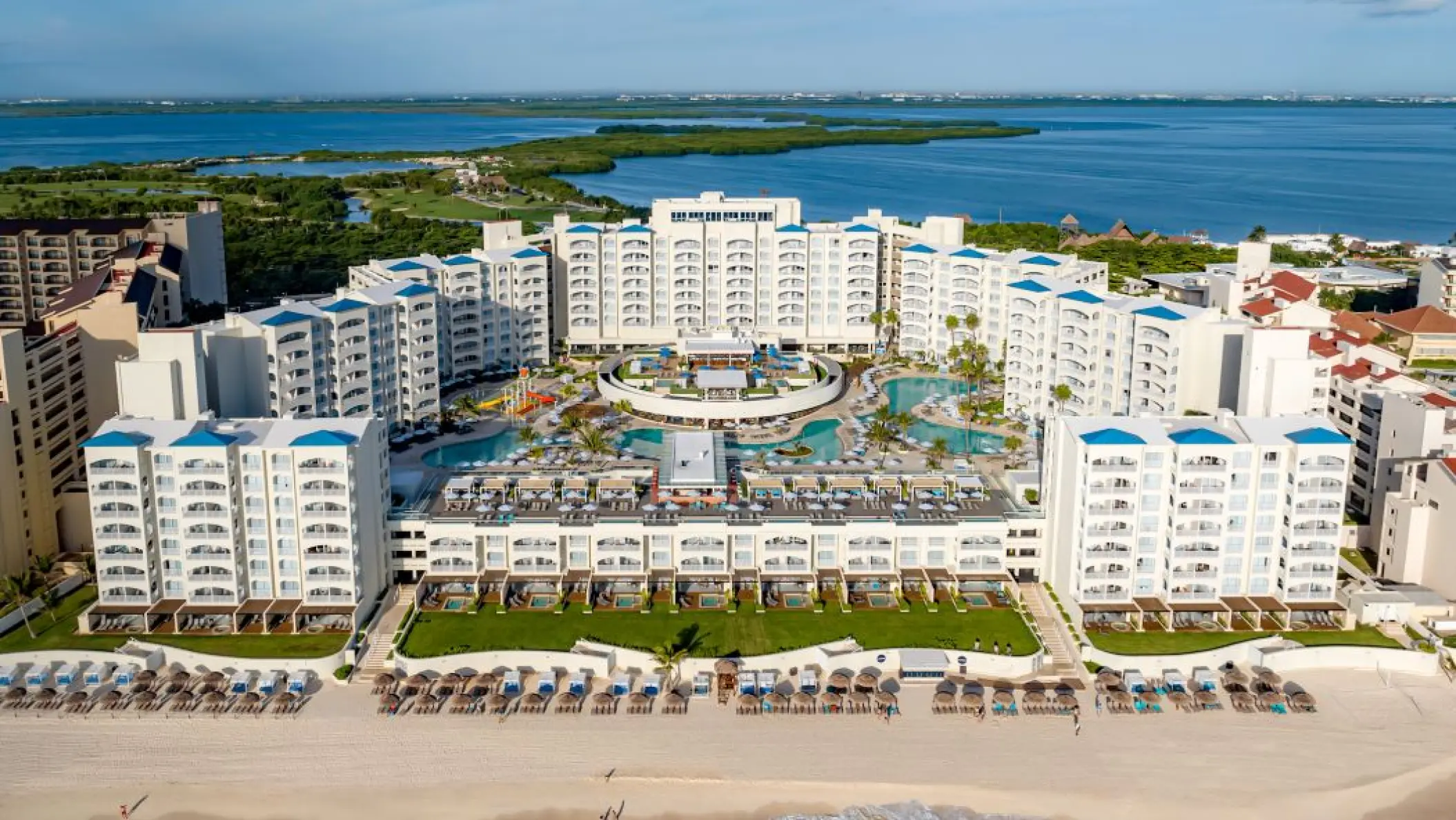 Aerial view of Hilton Cancun Mar Caribe buildings and pools overlooking the turquoise ocean, Cancun