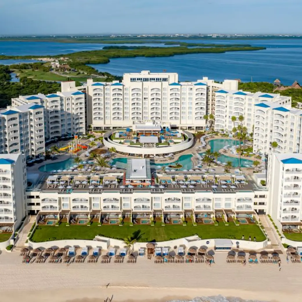 Aerial view of Hilton Cancun Mar Caribe buildings and pools overlooking the turquoise ocean, Cancun