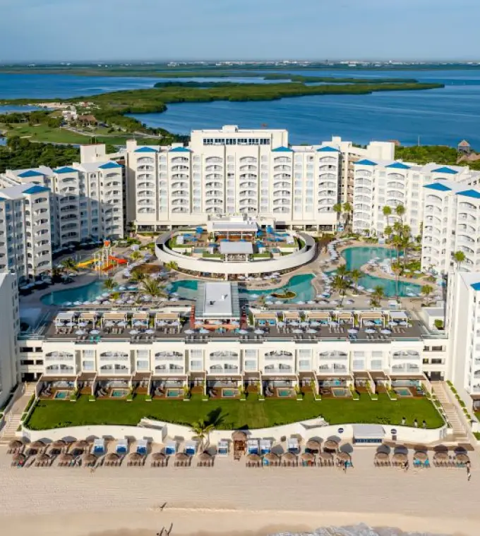 Aerial view of Hilton Cancun Mar Caribe buildings and pools overlooking the turquoise ocean, Cancun