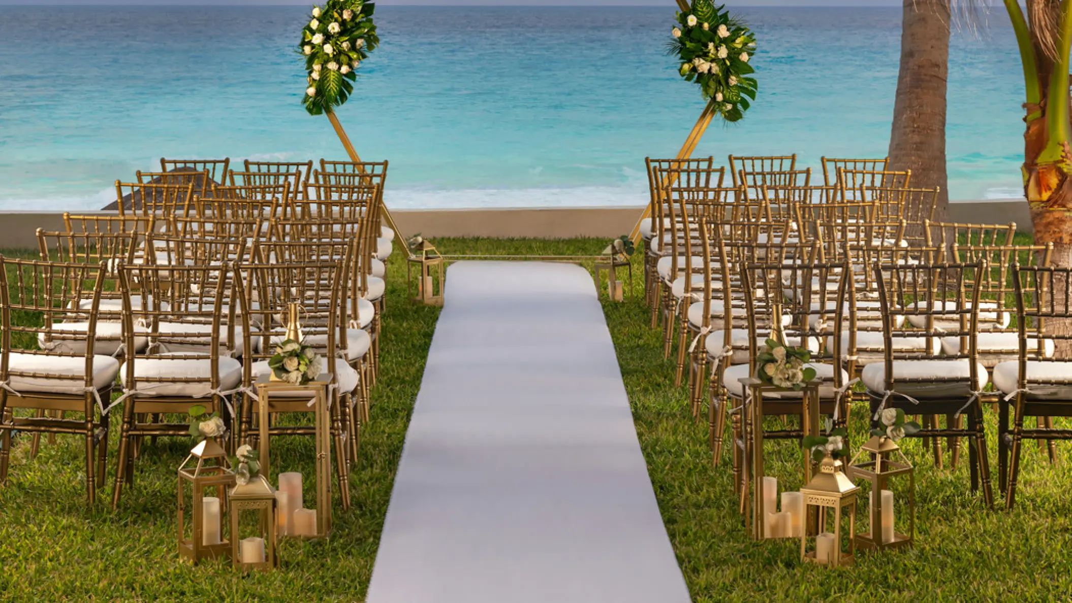 South Garden wedding ceremony with gold chairs and floral arch at Hilton Cancun Mar Caribe, Cancun