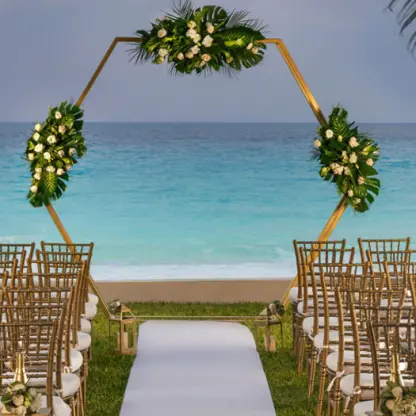 Hexagonal floral arch and gold chairs at a garden wedding ceremony at Hilton Cancun Mar Caribe, Cancun