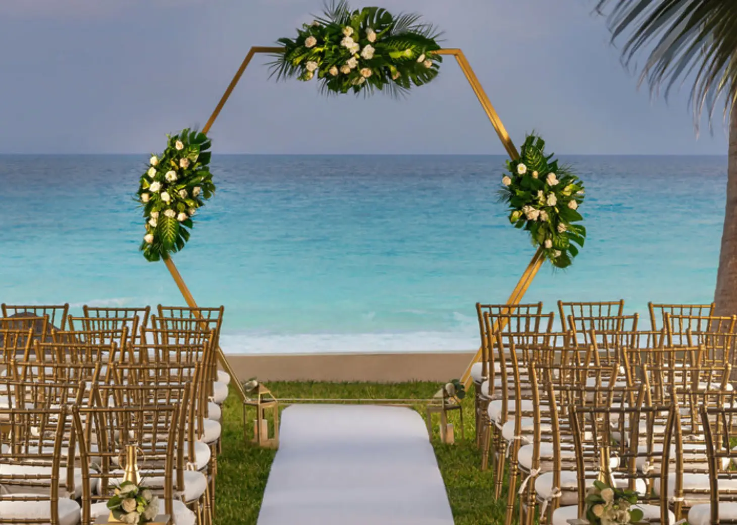 Hexagonal floral arch and gold chairs at a garden wedding ceremony at Hilton Cancun Mar Caribe, Cancun