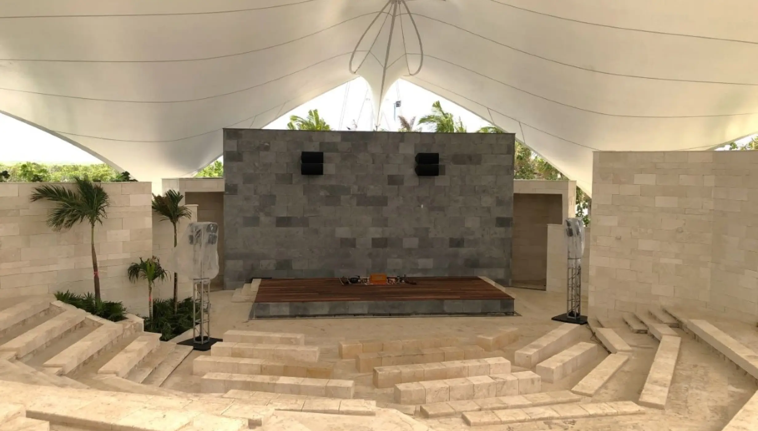 Amphitheater wedding venue with stone seating and a white canopy at Hilton Cancun, Cancun