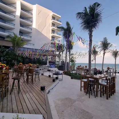 Outdoor wedding reception setup with wooden deck and bistro tables at Hilton Cancun, Cancun