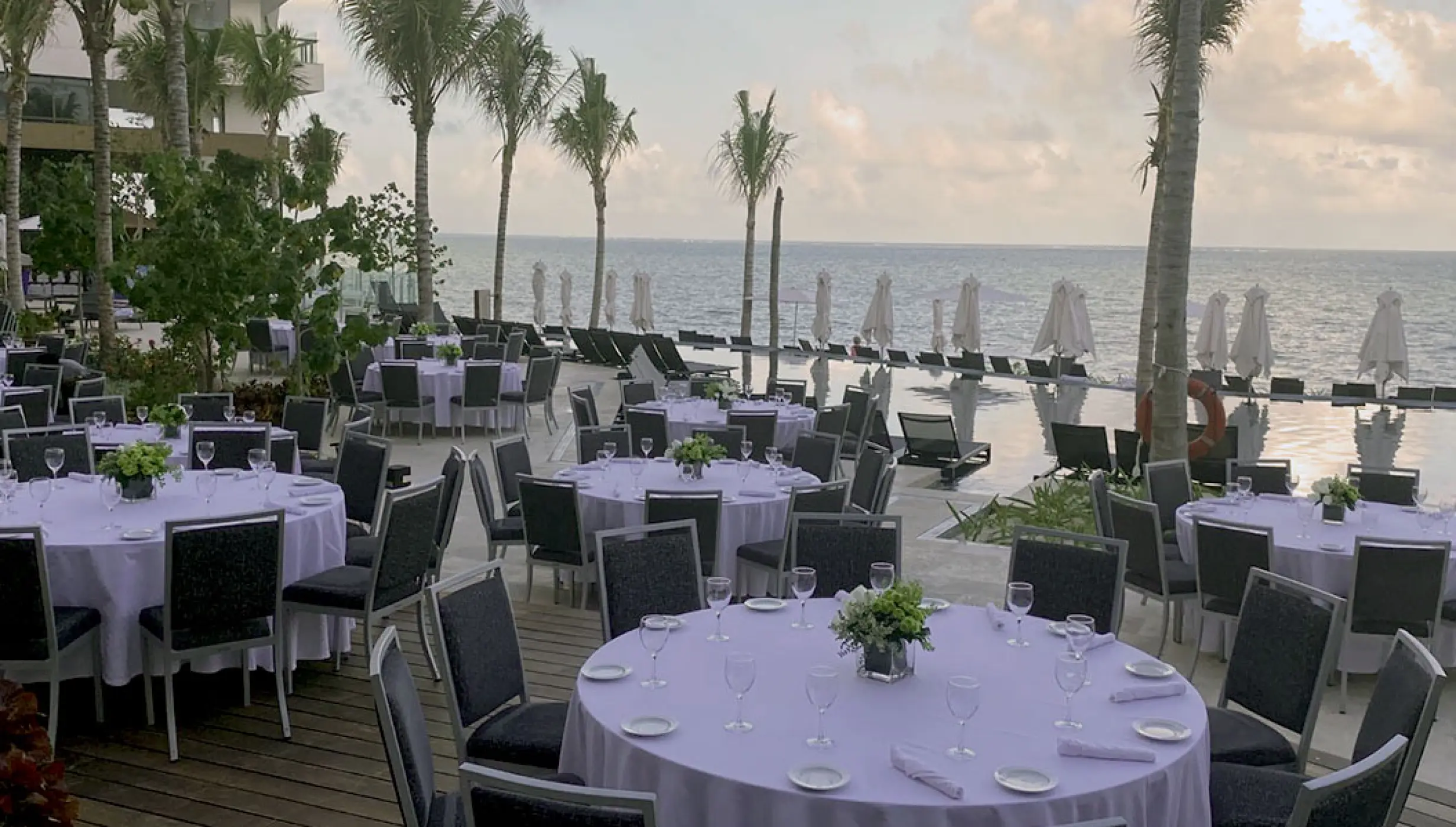 Wedding reception tables set on the pool deck at Hilton Cancun