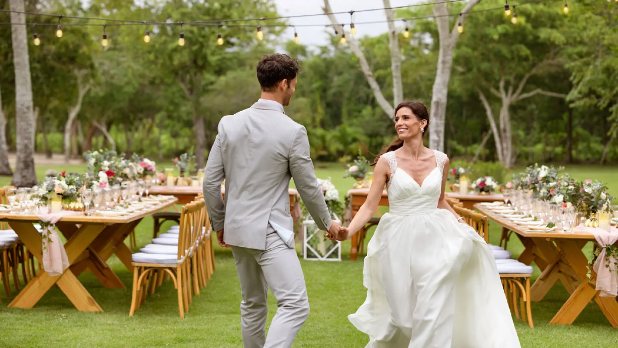 Bride and groom entering their garden wedding reception at Hilton La Romana