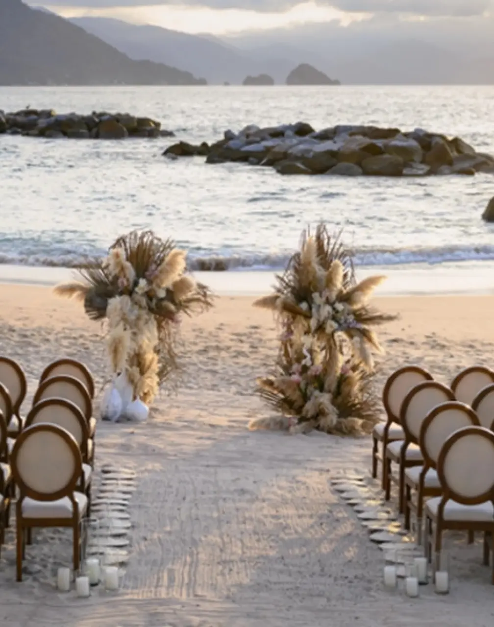Beach wedding ceremony with pampas grass decor at Hilton Vallarta Riviera, Puerto Vallarta