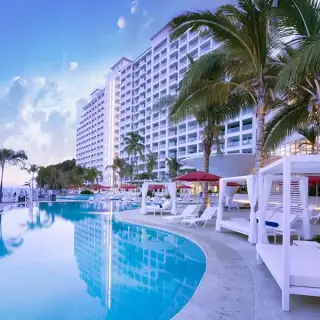 Hilton Vallarta Riviera infinity pool and white daybeds at dusk, Puerto Vallarta