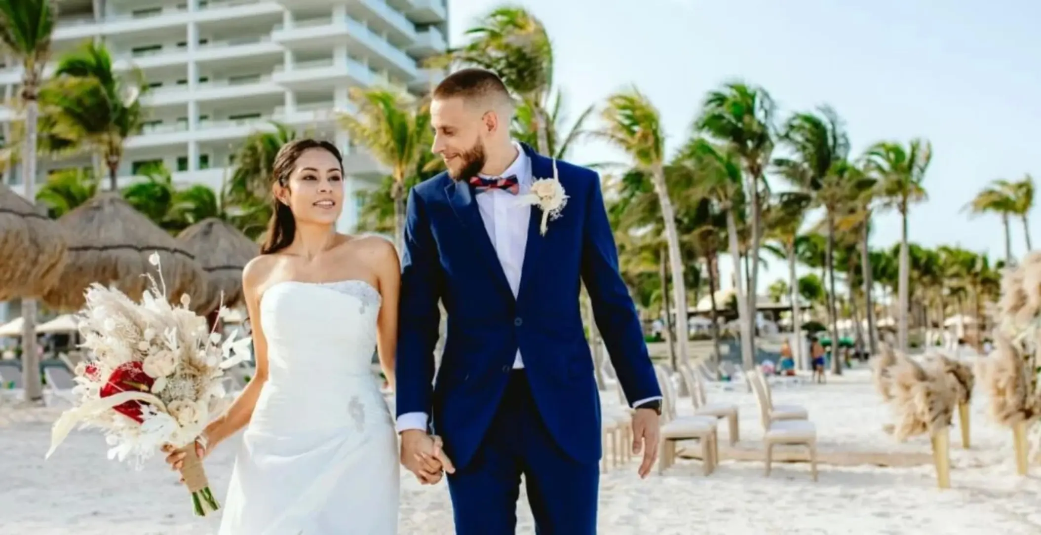 Bride and groom walking on the beach at Hotel Mousai, Cancun