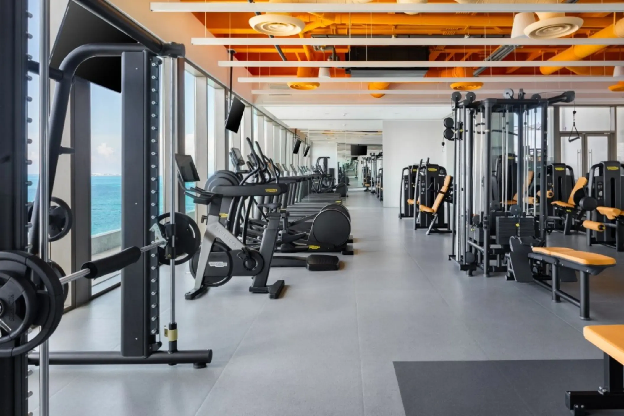 Fitness center with weight machines and ocean views at Hotel Mousai Cancun
